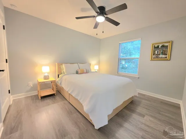 a bedroom with a bed and wooden floor