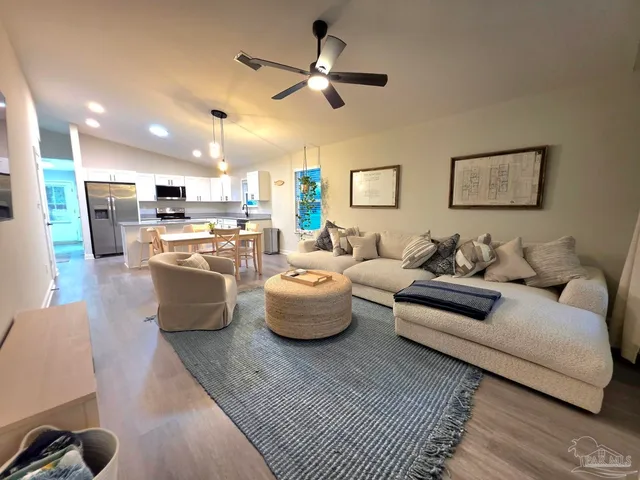 a living room with furniture and a view of kitchen