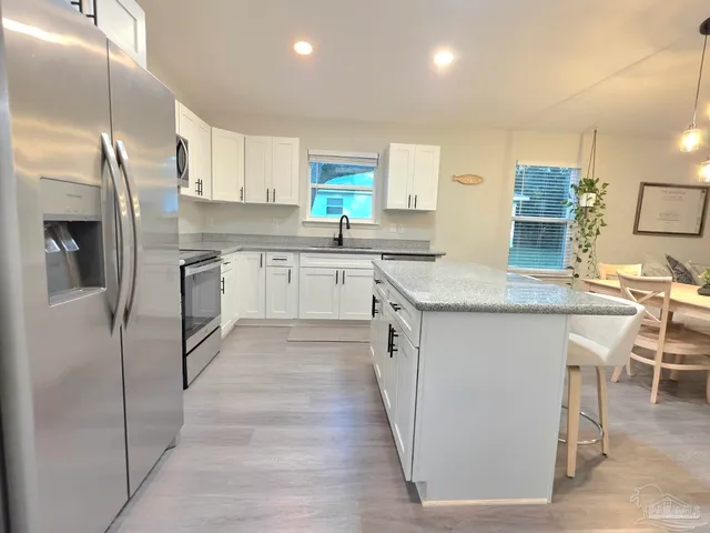 a large kitchen with cabinets and chairs