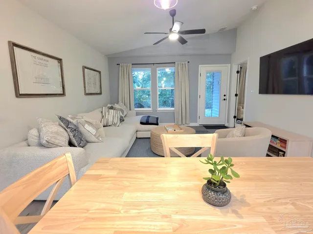 a living room with couches painting on the wall and a flat screen tv