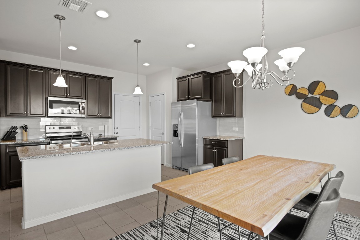13005 Foreston Drive Austin, TX 78754 - Photo 10 of 36 a kitchen with kitchen island granite countertop stainless steel appliances a fireplace sink microwave and cabinets