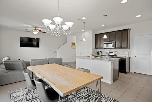 a kitchen with stainless steel appliances granite countertop a sink a stove and a refrigerator