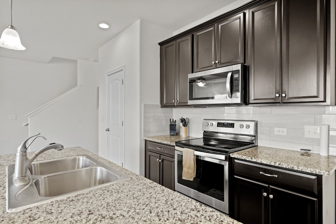 13005 Foreston Drive Austin, TX 78754 - Photo 15 of 36 a kitchen with stainless steel appliances granite countertop a sink stove and microwave
