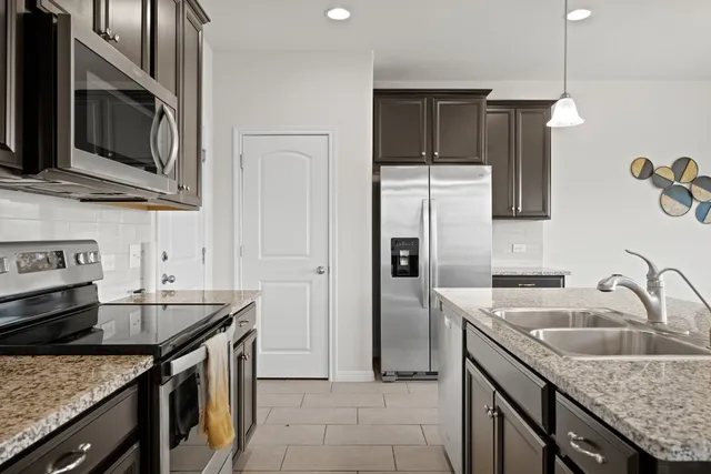 a kitchen with stainless steel appliances granite countertop a sink stove and refrigerator