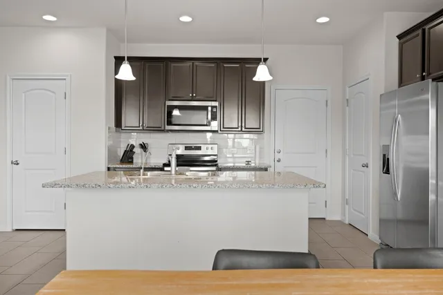 a kitchen with stainless steel appliances granite countertop a sink stove and microwave