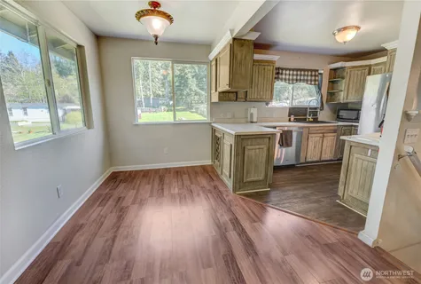 a kitchen with a wooden floor stove top oven and refrigerator