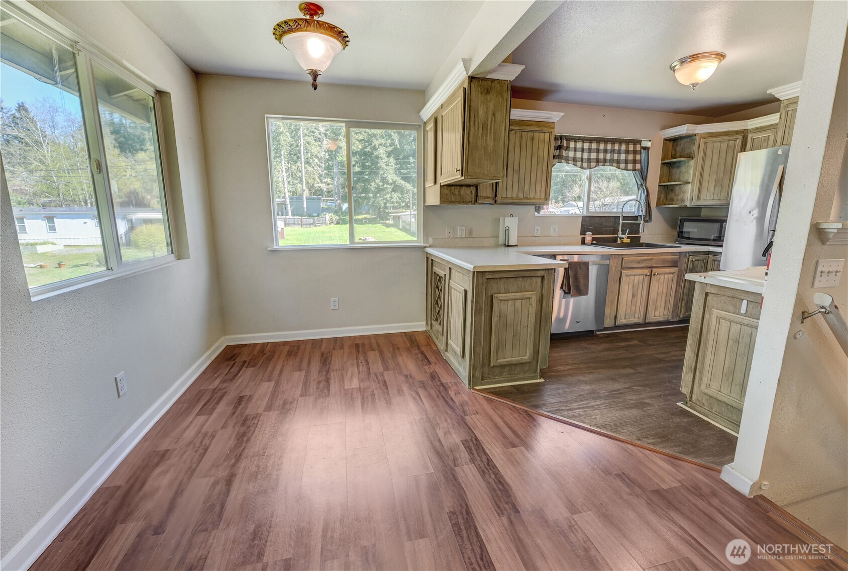 8210 176th Avenue Southwest Longbranch, WA 98351 - Photo 11 of 28 a kitchen with a wooden floor stove top oven and refrigerator