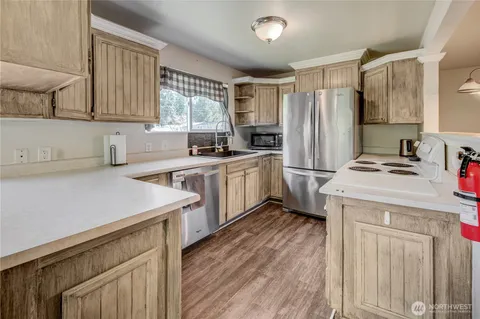 a kitchen with a sink a stove a refrigerator and cabinets