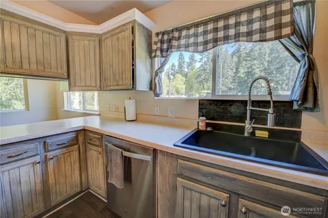 a kitchen with a large window sink and cabinets