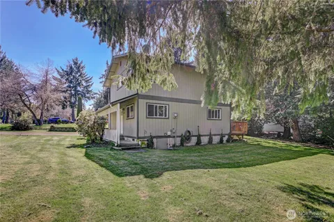 a front view of a house with a yard and trees