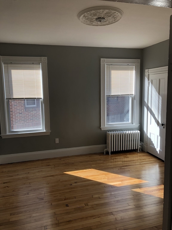 203 High Street Brookline, MA 02445 - Photo 13 of 18 an empty room with wooden floor and windows