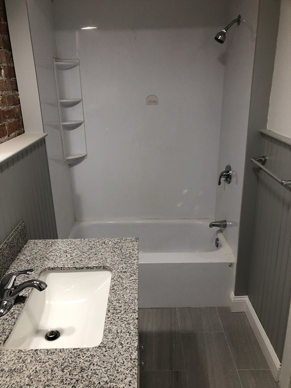 203 High Street Brookline, MA 02445 - Photo 14 of 18 a bathroom with a sink a bath tub and a shower