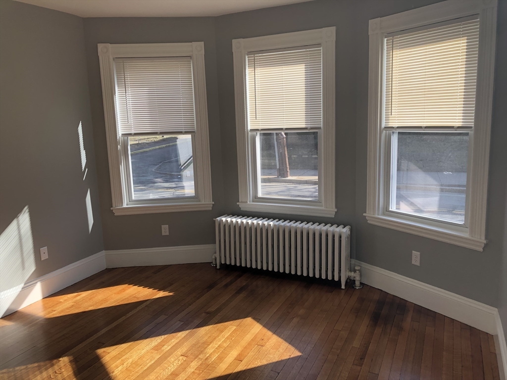 203 High Street Brookline, MA 02445 - Photo 8 of 18 an empty room with wooden floor and windows
