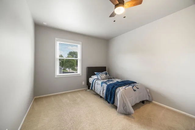a bed sitting in a bedroom next to a window