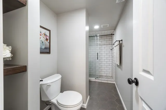 a bathroom with a toilet and shower