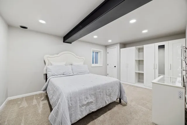 a spacious bedroom with a bed and a large window