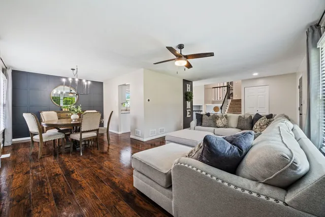 a living room with furniture and a wooden floor