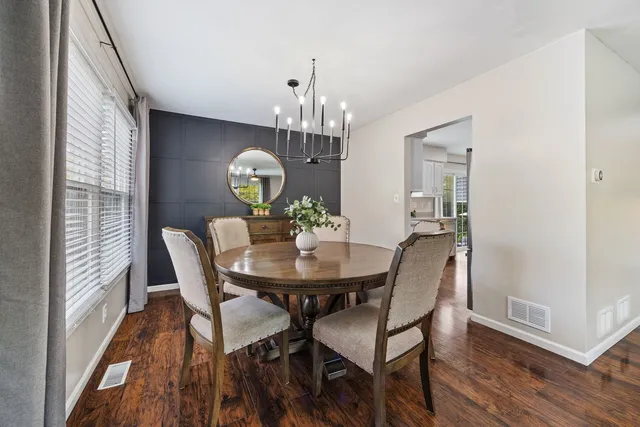 a view of a dining room with furniture a chandelier and wooden floor