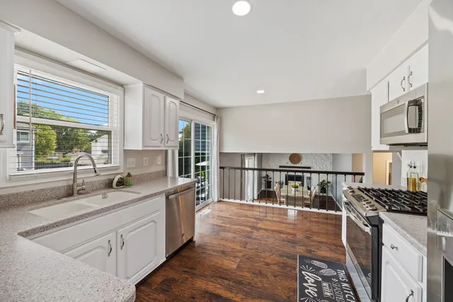 a kitchen with stainless steel appliances granite countertop a sink stove and cabinets