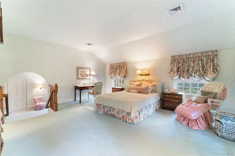 a spacious bedroom with two beds and window