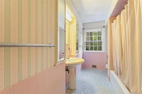 a bathroom with a sink a bathtub and a window