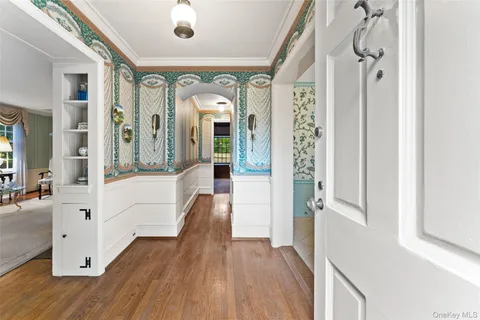 a view of a hallway with wooden floor and windows