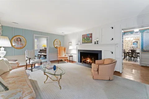 a living room with furniture a clock and a fireplace