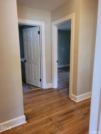 a view of a hallway with wooden floor