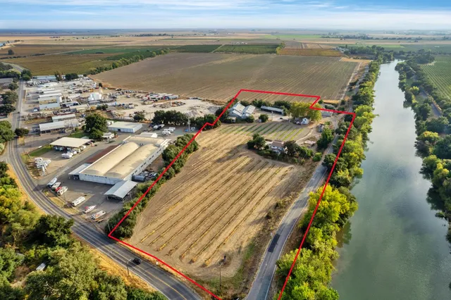an aerial view of residential houses with outdoor space and lake view
