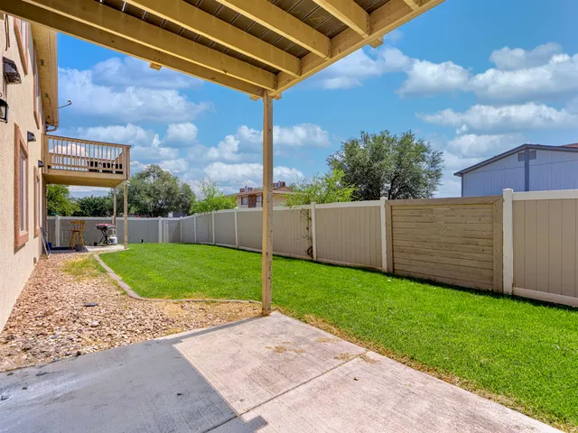 a view of a backyard with brick wall and plants