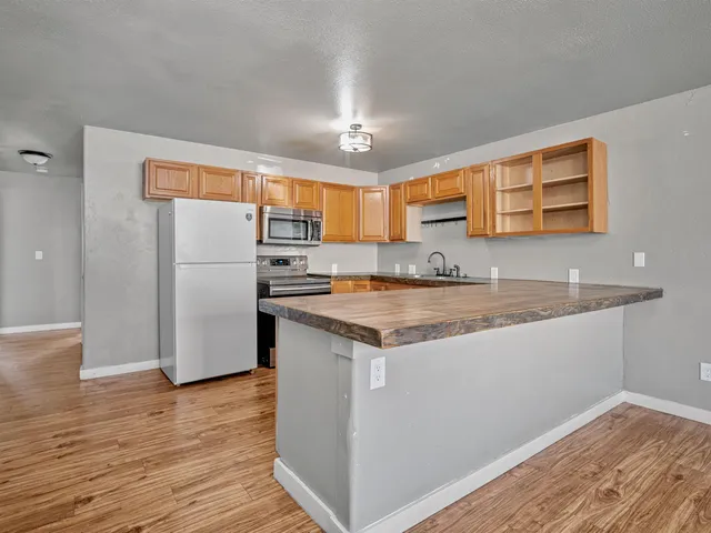 a kitchen with stainless steel appliances granite countertop a refrigerator and a sink