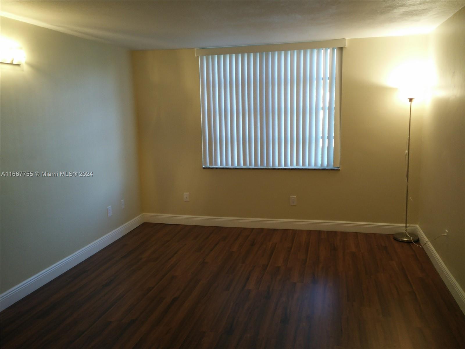 3285 Foxcroft Road, Unit E107 Miramar, FL 33025 - Photo 4 of 9 an empty room with wooden floor and windows