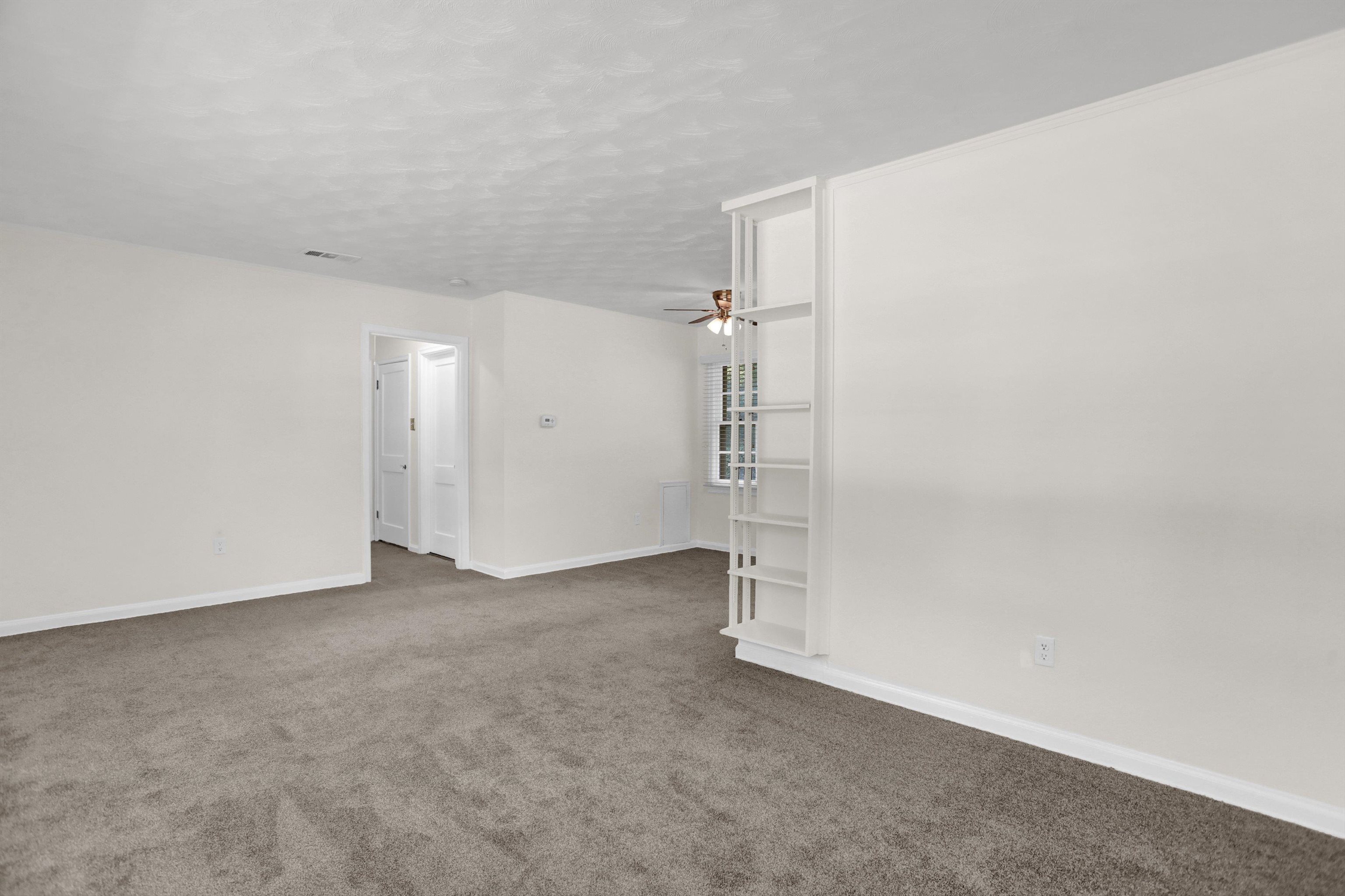 4545 Flamingo Road Memphis, TN 38117 - Photo 8 of 34 Open concept room featuring neutral tone carpeting and crisp white walls