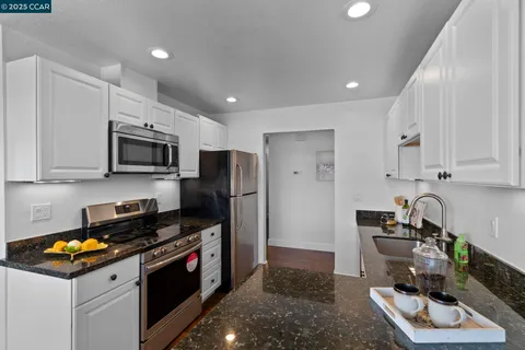 a kitchen with stainless steel appliances granite countertop a stove and a microwave
