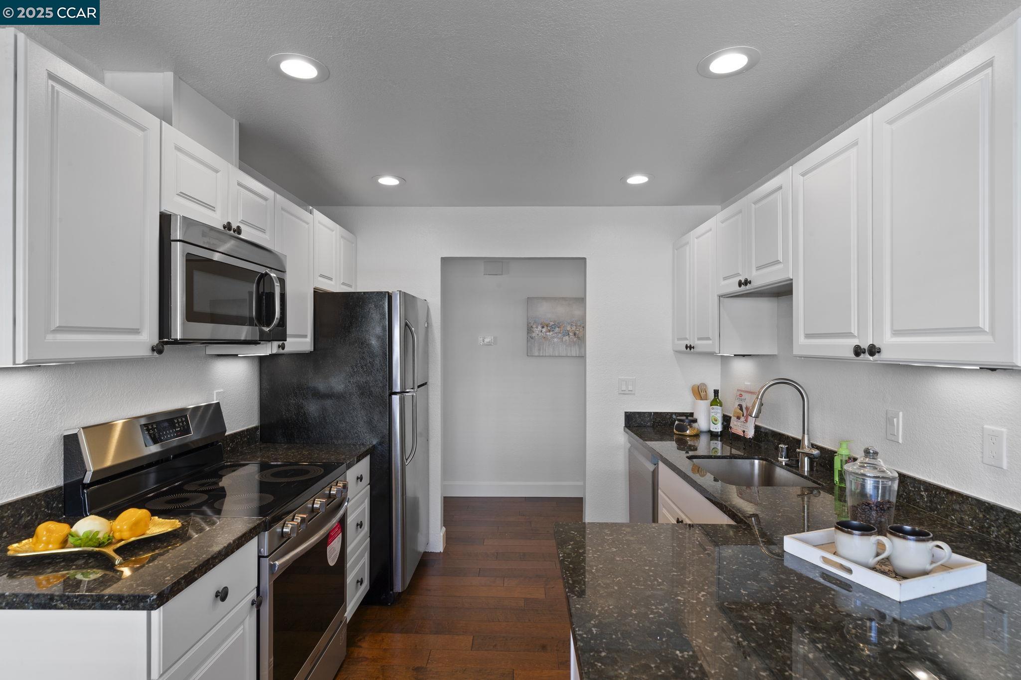 5050 Valley Crest Drive, Unit 63 Concord, CA 94521 - Photo 15 of 55 a kitchen with stainless steel appliances granite countertop a stove refrigerator sink and microwave