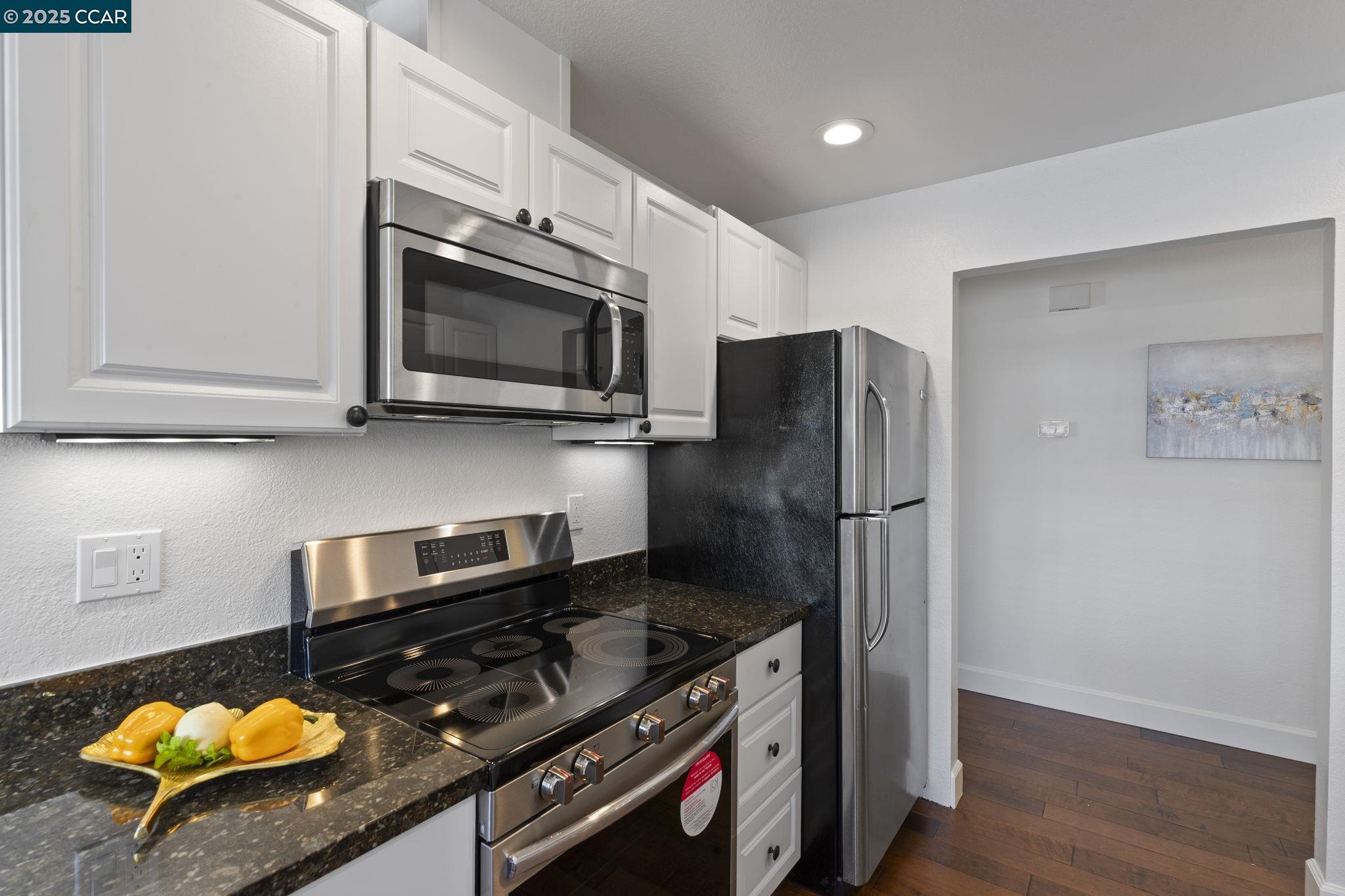5050 Valley Crest Drive, Unit 63 Concord, CA 94521 - Photo 16 of 55 a kitchen with stainless steel appliances granite countertop a stove and a microwave
