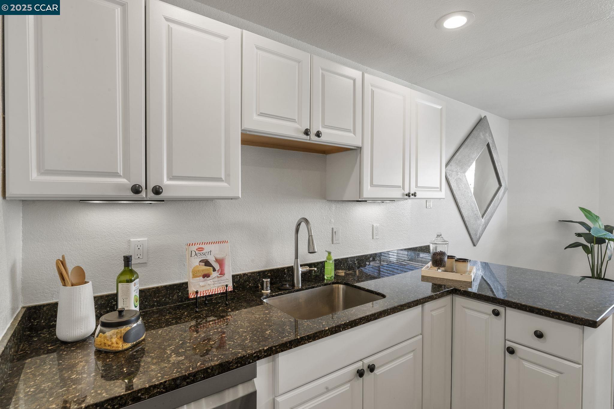 5050 Valley Crest Drive, Unit 63 Concord, CA 94521 - Photo 20 of 55 a kitchen with white cabinets and a sink