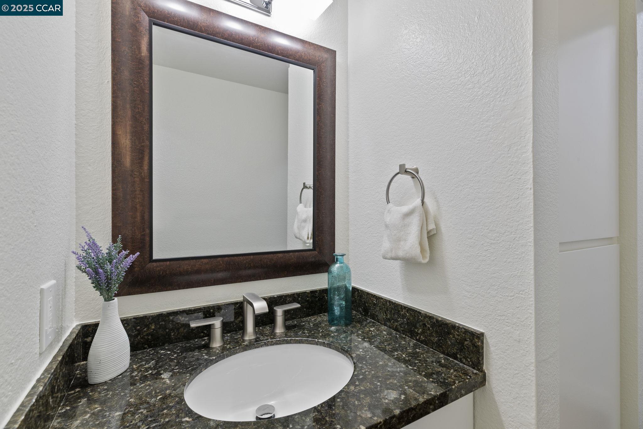 5050 Valley Crest Drive, Unit 63 Concord, CA 94521 - Photo 36 of 55 a bathroom with a granite countertop sink and a mirror