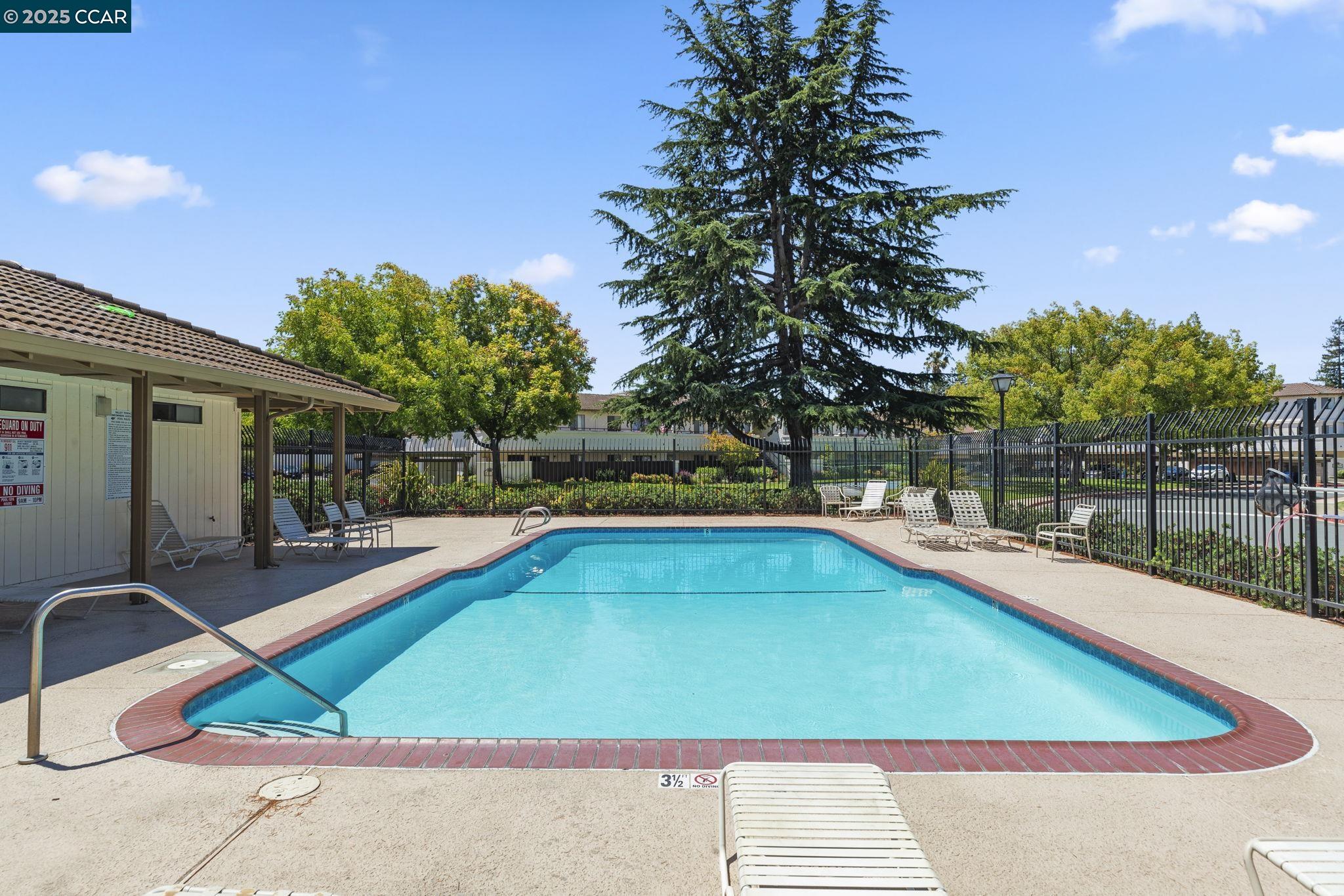 5050 Valley Crest Drive, Unit 63 Concord, CA 94521 - Photo 54 of 55 a small pool with lawn chairs under an umbrella