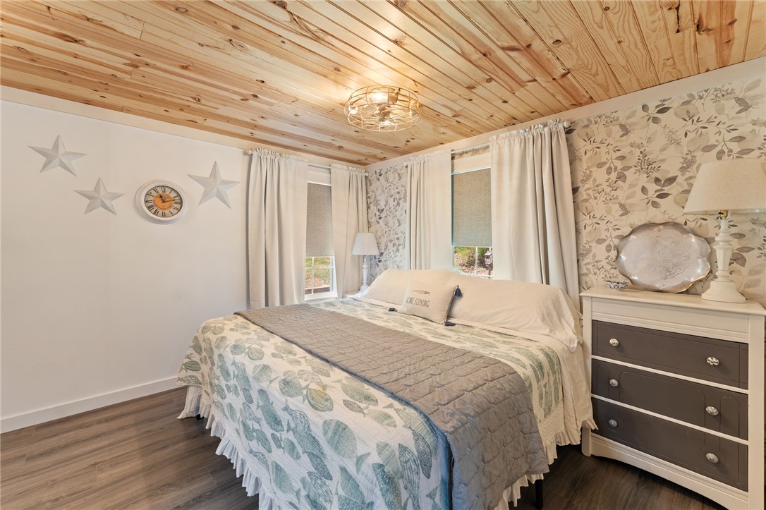 30 Mobleys Bluff Road Abbeville, SC 29620 - Photo 28 of 35 Warm wood-planked ceilings and wood-look flooring establish a cozy atmosphere in this bedroom.