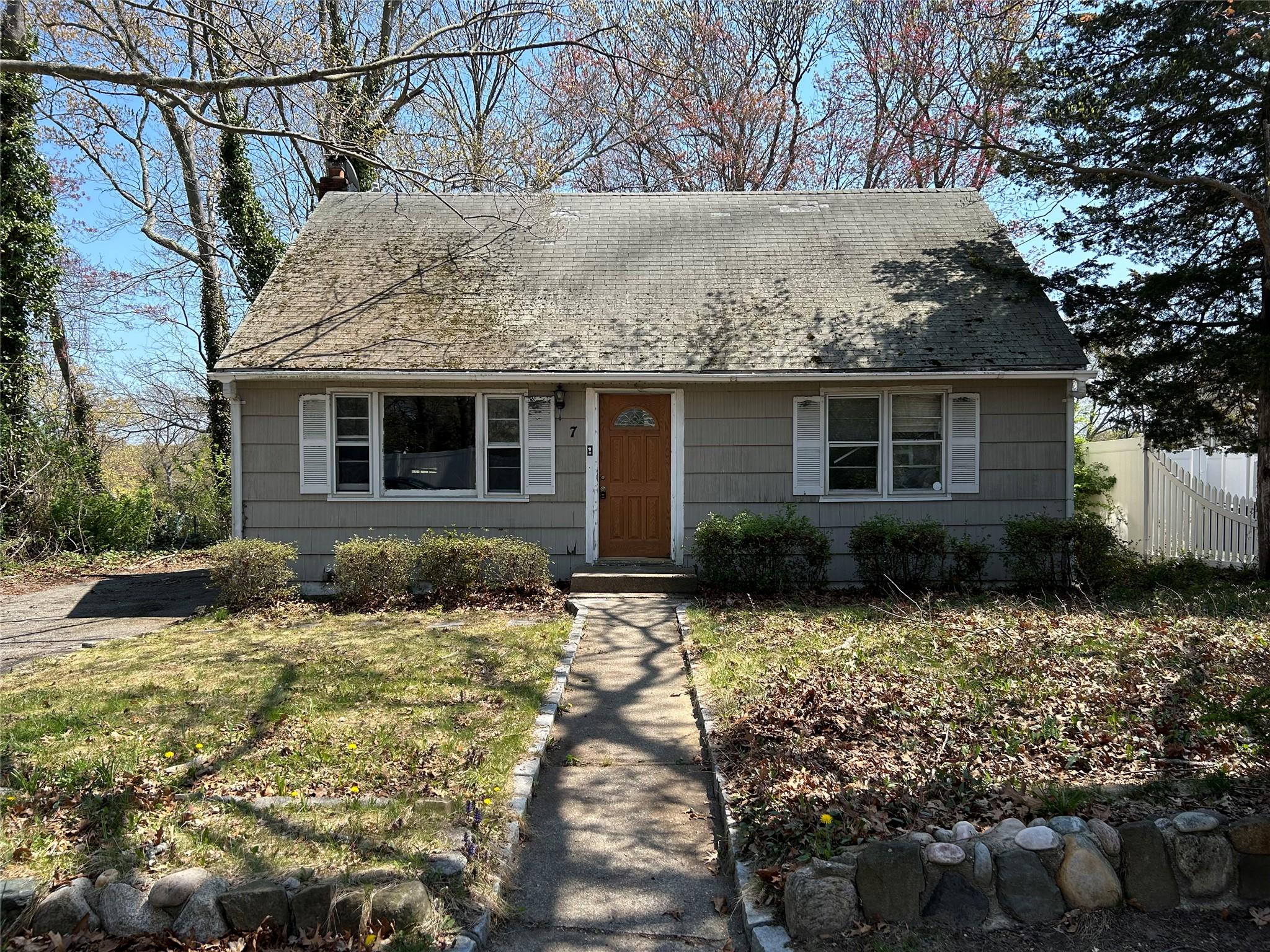 7 Sea Cliff Road Sound Beach, NY 11789 - Photo 1 of 1 View of front of property featuring a chimney, a front lawn, fence, and a shingled roof