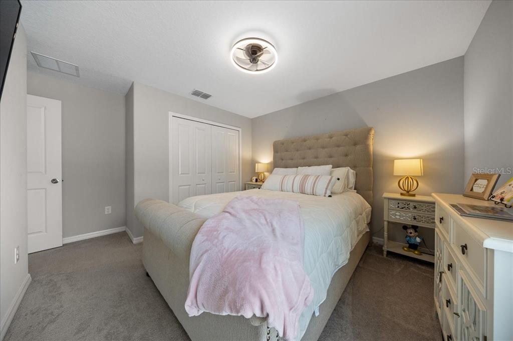 9329 Southwest 57th Terrace Ocala, FL 34476 - Photo 33 of 64 a spacious bedroom with a bed and a lamp