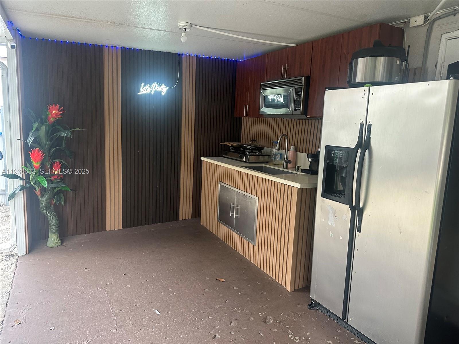 13200 Southwest 264th Street, Unit MAIN Homestead, FL 33032 - Photo 13 of 20 a kitchen with stainless steel appliances a refrigerator and a stove