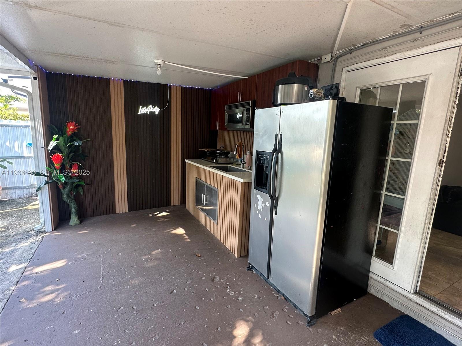 13200 Southwest 264th Street, Unit MAIN Homestead, FL 33032 - Photo 14 of 20 a kitchen with stainless steel appliances a refrigerator and a sink