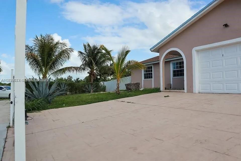 13200 Southwest 264th Street, Unit MAIN Homestead, FL 33032 - Photo 2 of 20 a house with a yard and a garage