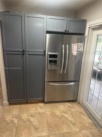 a kitchen with a refrigerator and wooden floor