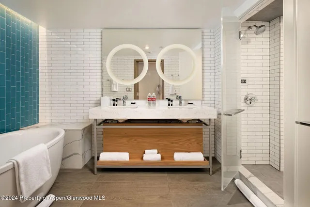 a bathroom with a double vanity sink mirror and shower