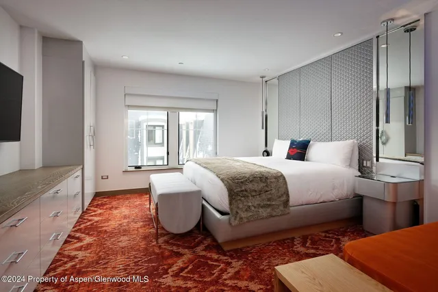 a spacious bedroom with a bed and a large window