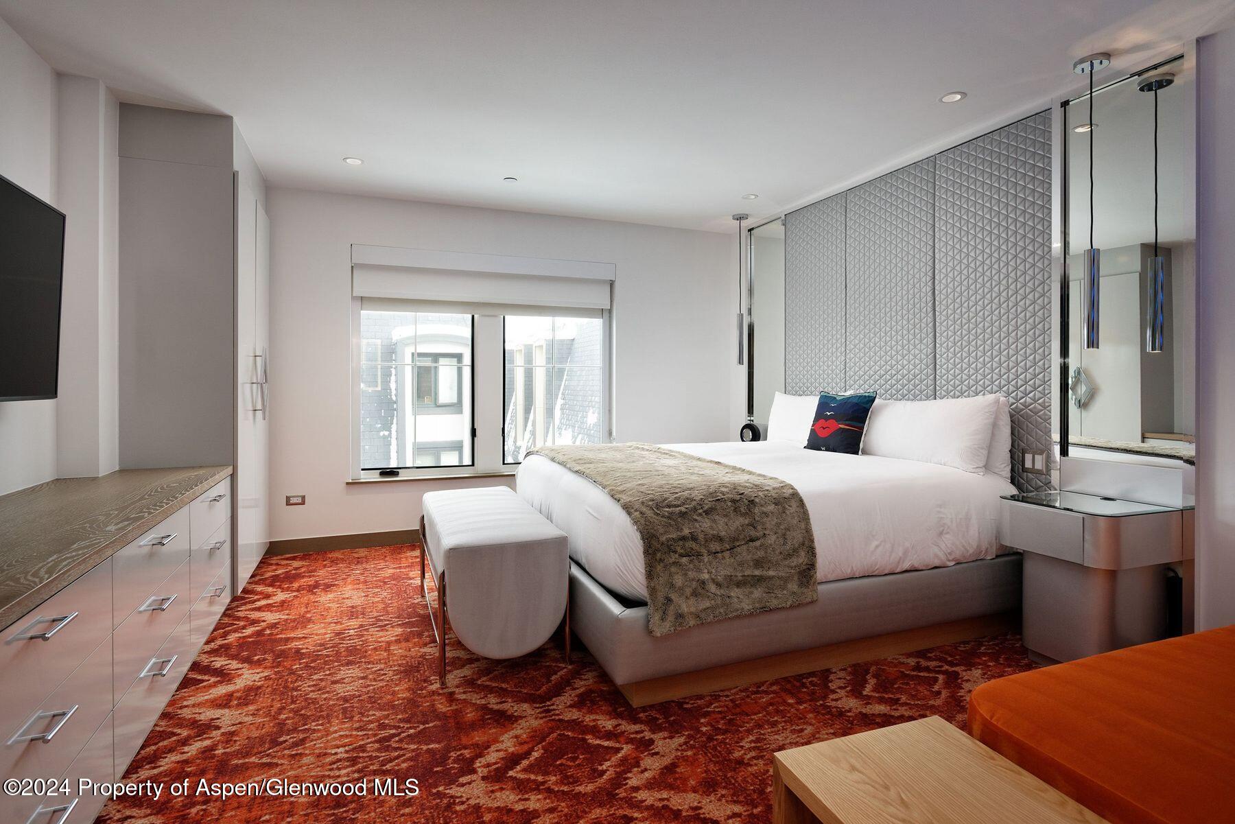 550 South Spring Street Aspen, CO 81611 - Photo 4 of 20 a spacious bedroom with a bed and a large window