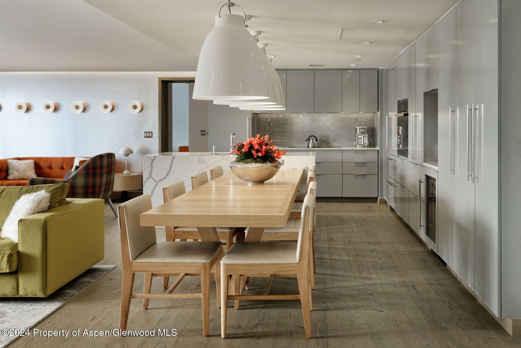 550 South Spring Street Aspen, CO 81611 - Photo 5 of 20 a kitchen with stainless steel appliances a dining table chairs and a refrigerator